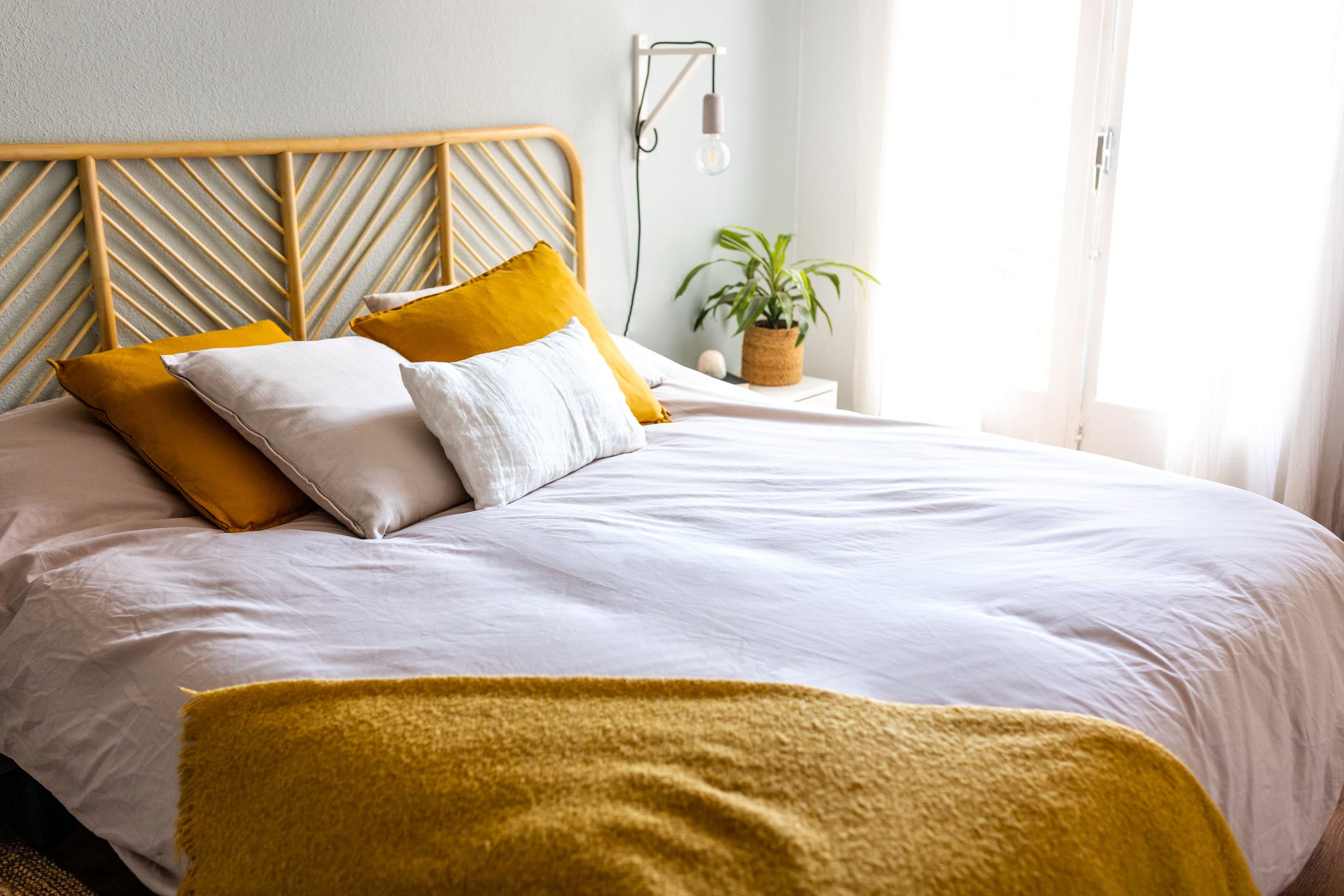 Freshly made bed in a bright, welcoming bedroom