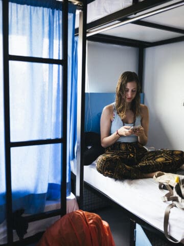 Backpacker on her phone at a hostel in Varanasi, India.