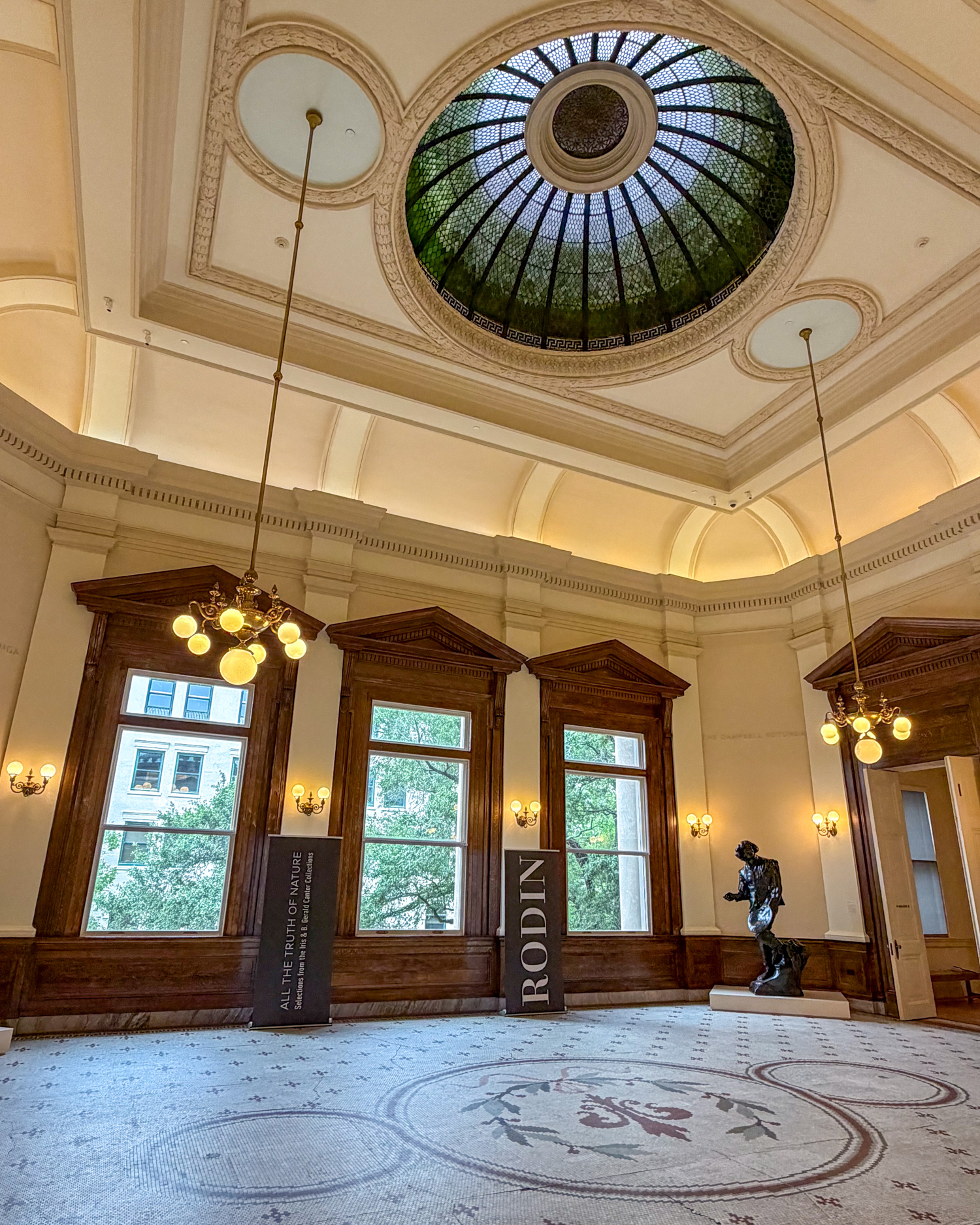Stained-glass dome, mosaic floor, and sculpture inside the Gibbes Museum of Art in Charleston.