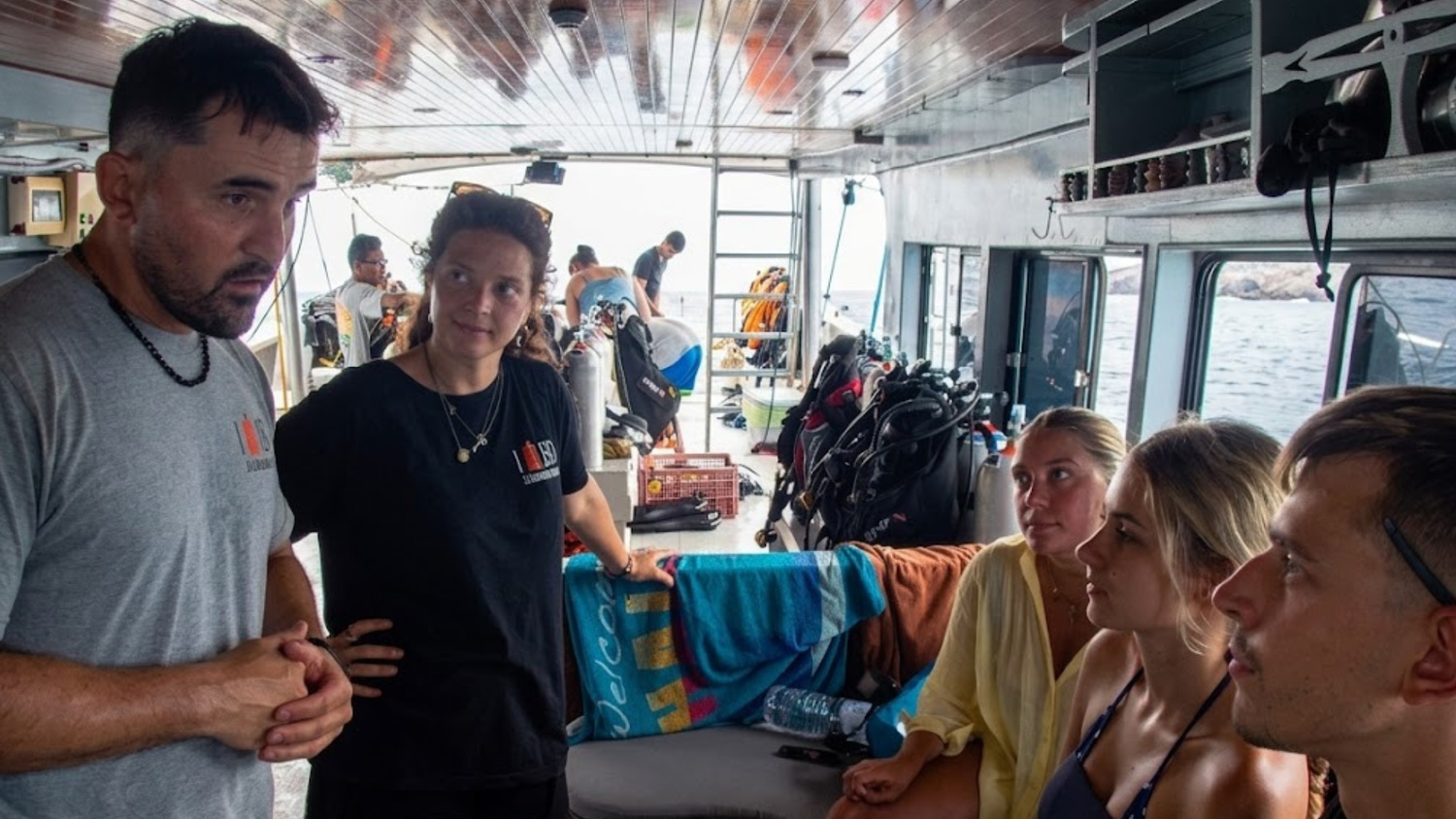 Two LB Diving instructors briefing three scuba students
