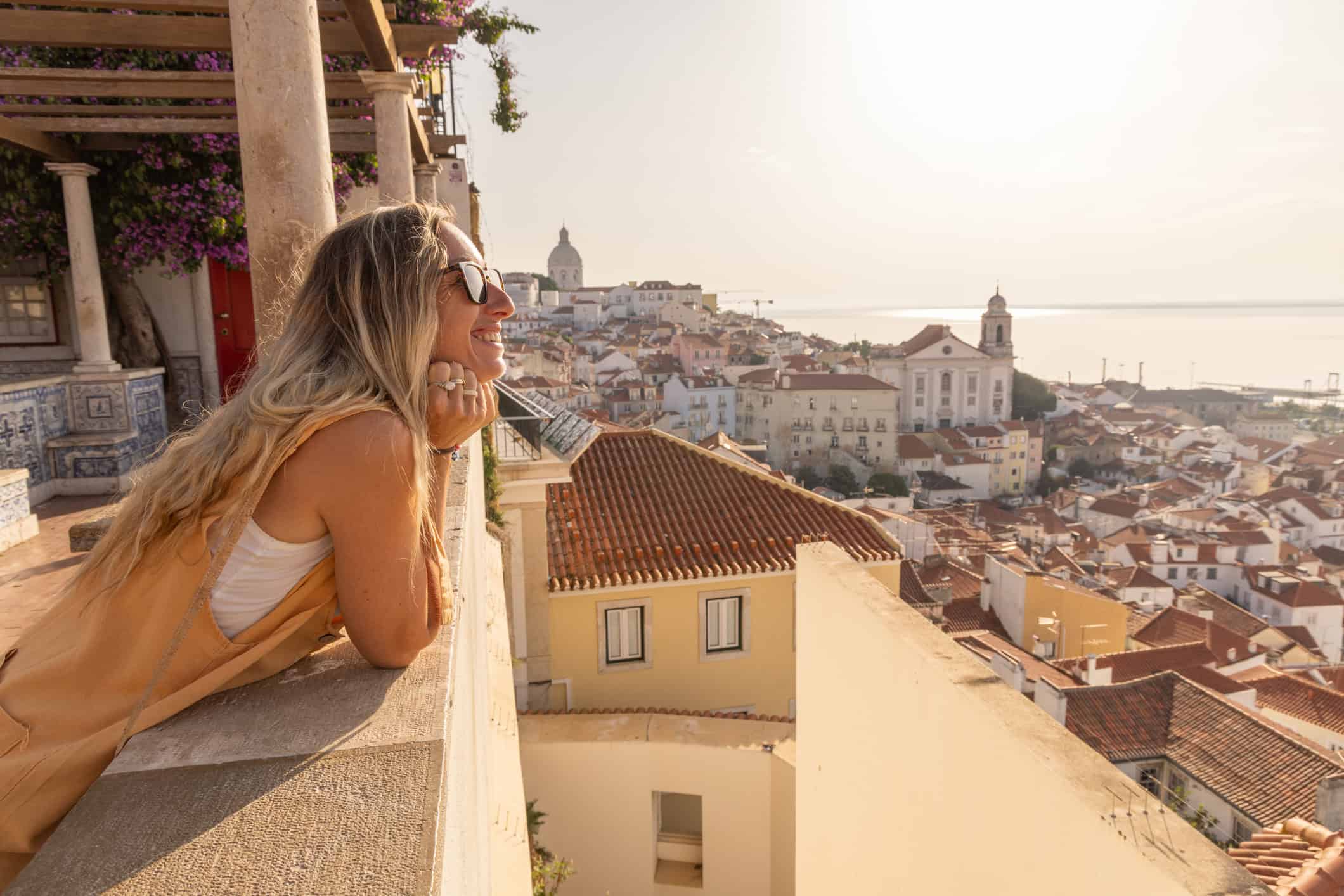 Woman overlooking Lisbon's Alfama district and the Tagus River in Portugal.