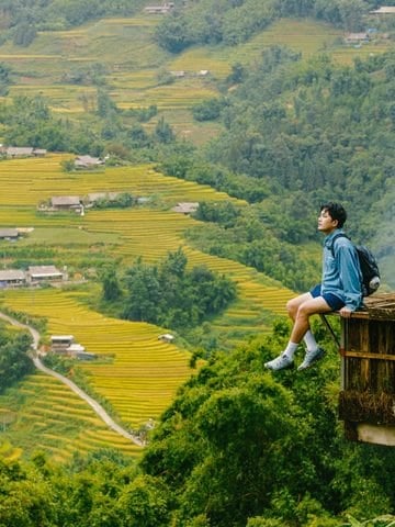 Backpacker sitting above terraced fields in Vietnam.