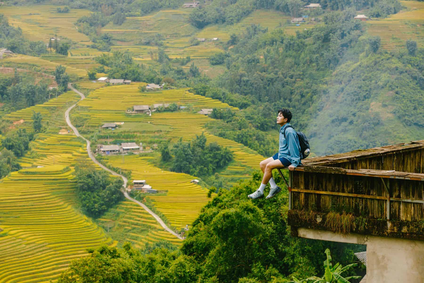 Backpacker sitting above terraced fields in Vietnam.