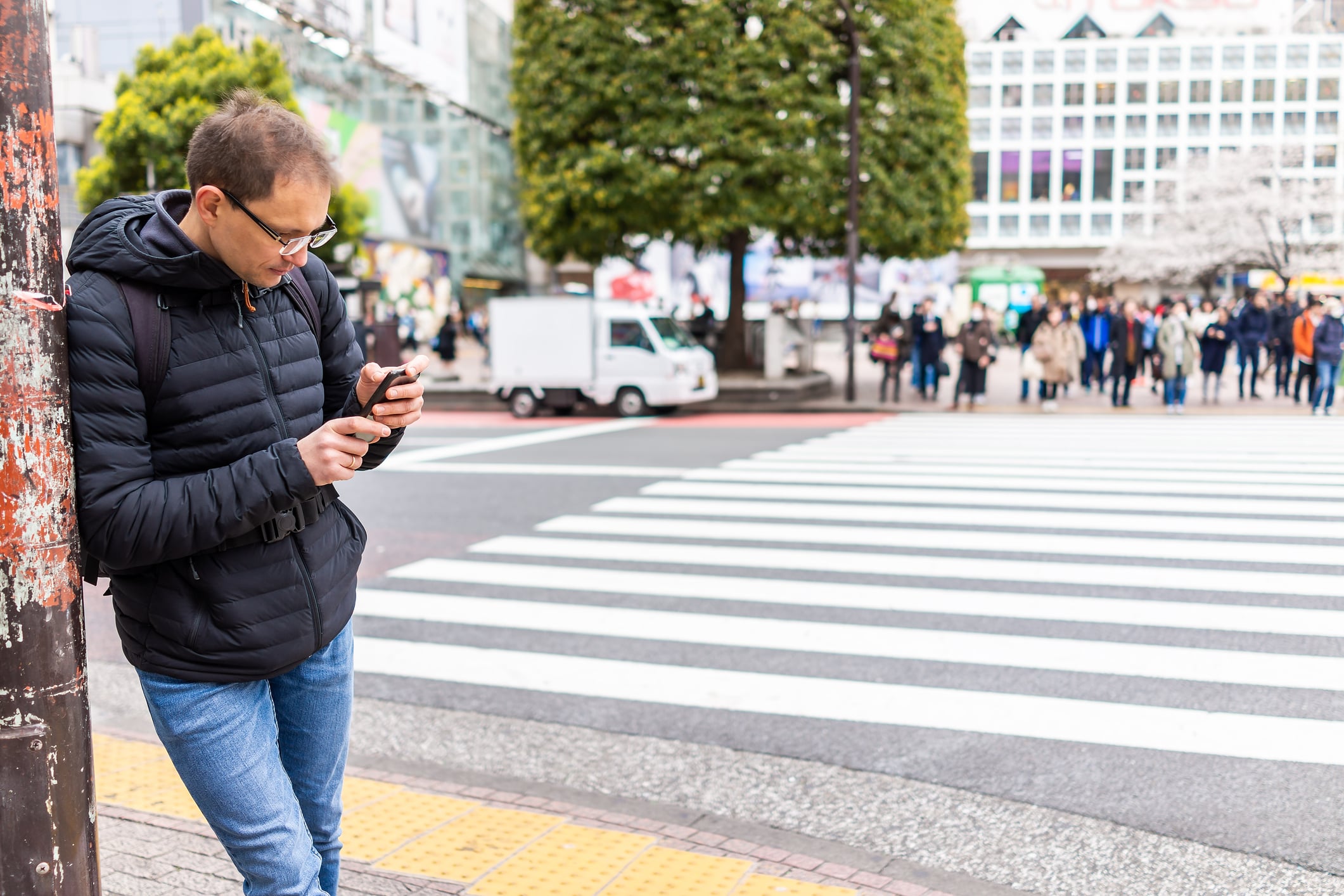 Traveler using a smartphone to navigate Shibuya in Tokyo