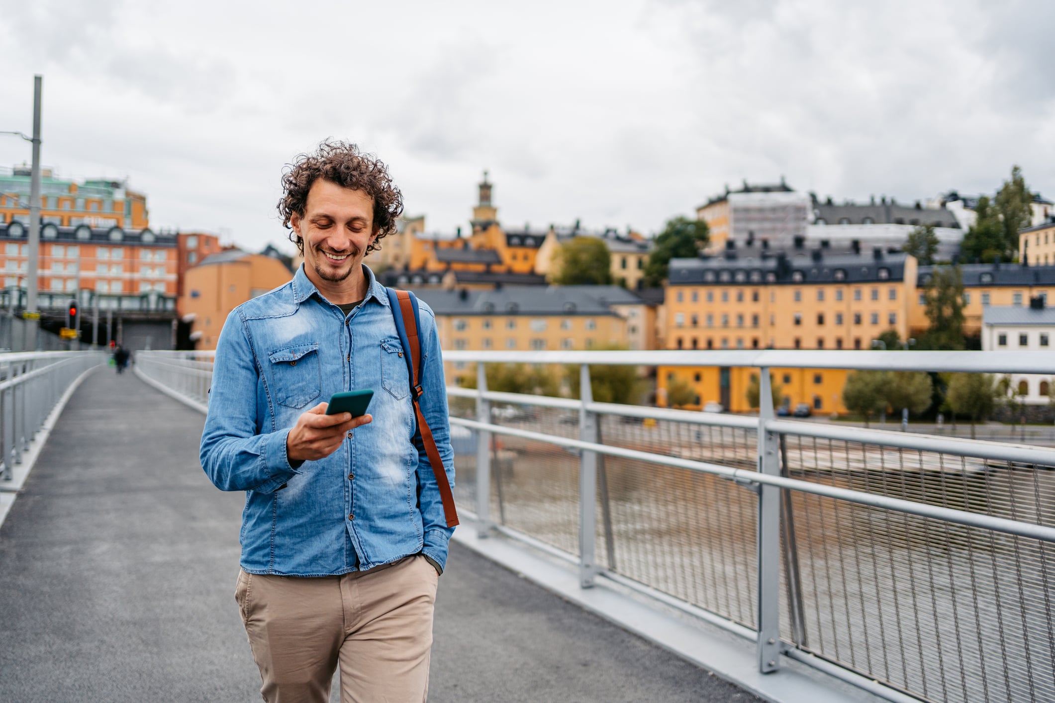 Traveler looking at his smartphone on a bridge in Stockholm, Sweden.